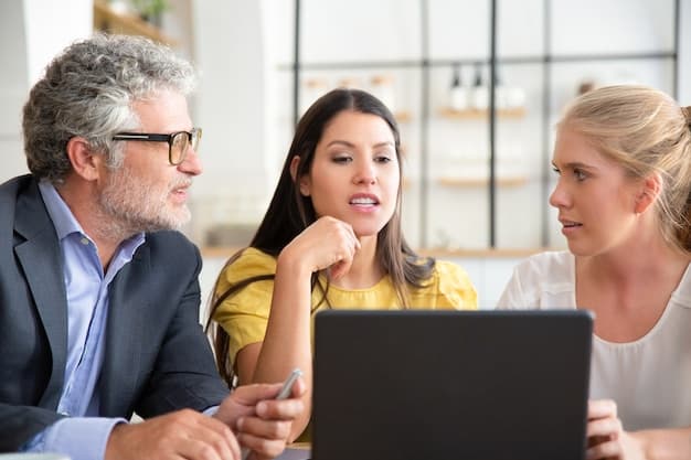 Tres profesionales conversando y revisando información en una computadora; imagen ilustrativa